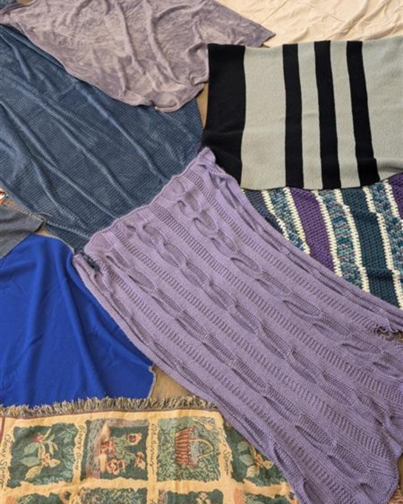 Several blankets overlap each other on the ground