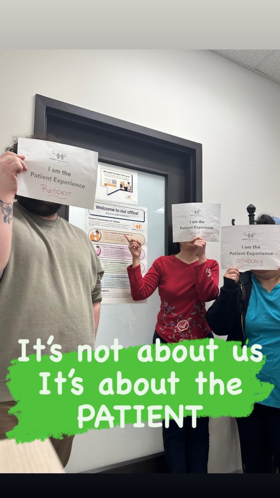 Dr. Zou’s Practice Team holding up "I am the patient experience" sign with text over top of the image that says "It's not about us it's about the patient."