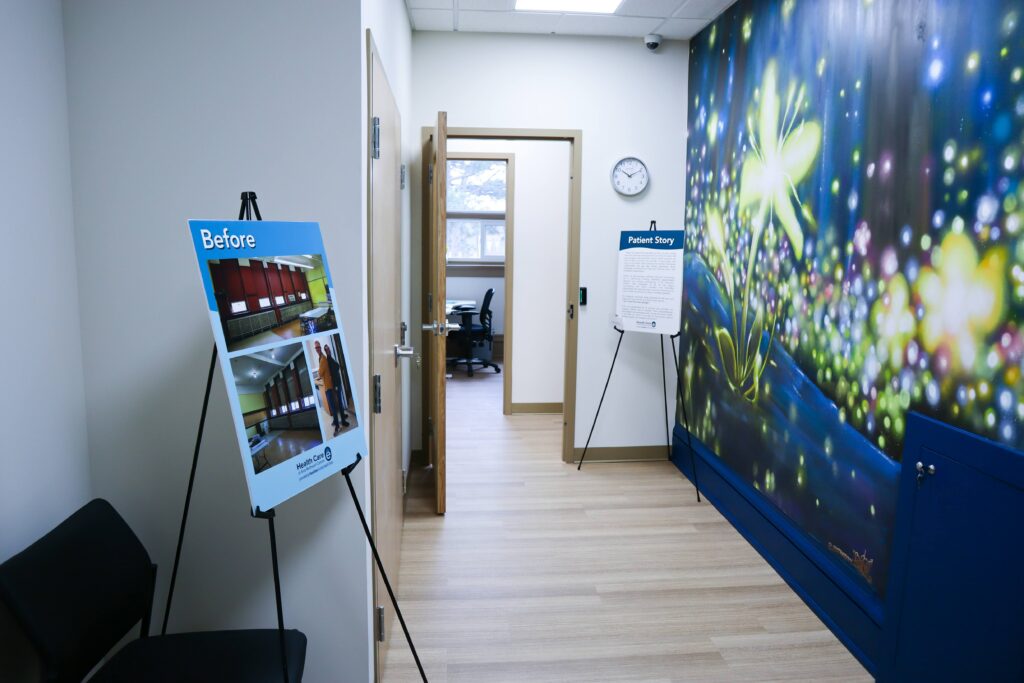 Clinical space entryway with a mural in dark blues and yellows showing bioluminescent plants.