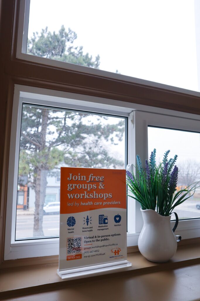 A large window with a sign in front of it that says "Join free groups and workshops."
