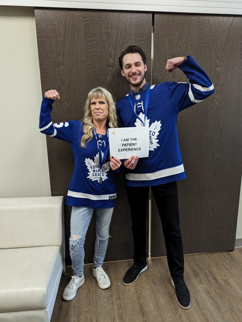 HFHT physio and admin support team wearing Toronto Maple Leafs jerseys and holding an "I am the patient experience" sign.